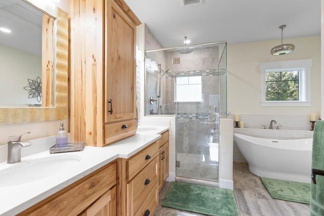 bathroom with hardwood / wood-style flooring, tile walls, separate shower and tub, and vanity