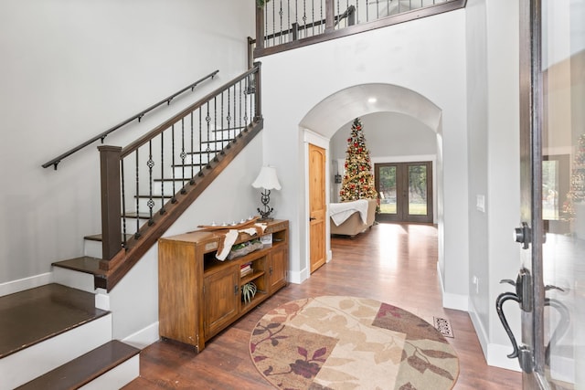 entryway with french doors, dark hardwood / wood-style floors, and a towering ceiling