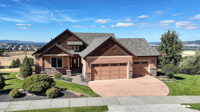 craftsman-style house featuring a front lawn, a mountain view, and a garage