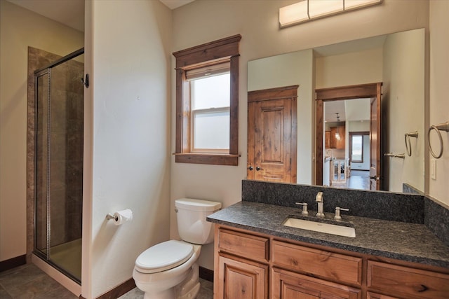 bathroom with an enclosed shower, vanity, and toilet