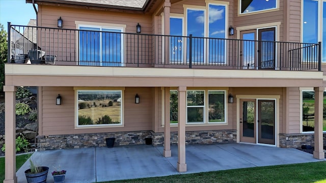 rear view of house featuring a patio area and a balcony