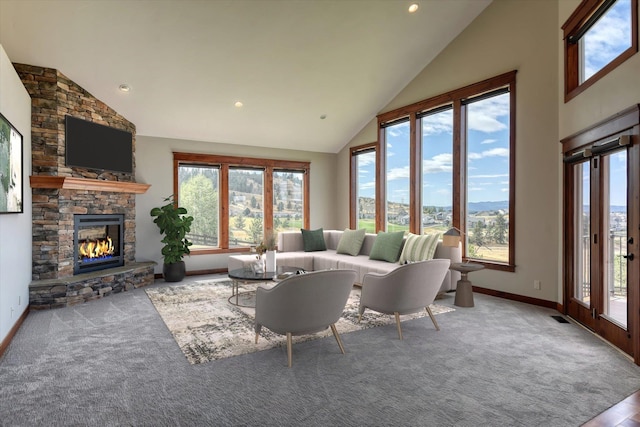 carpeted living room featuring high vaulted ceiling and a fireplace