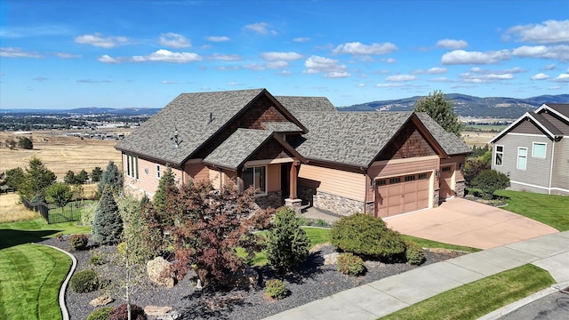 view of front of house featuring a mountain view, a front lawn, and a garage