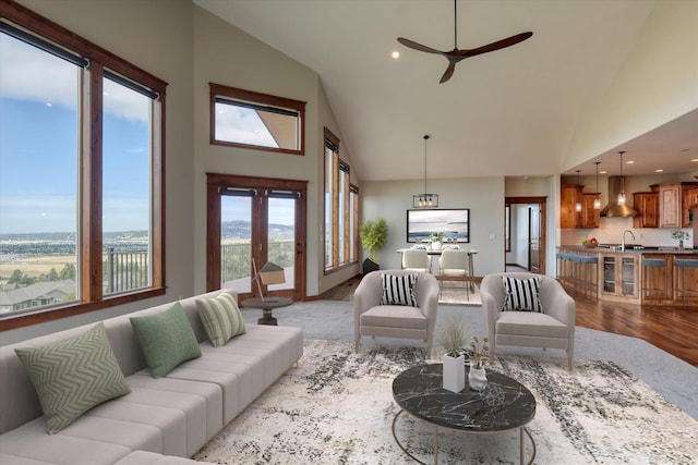 living room featuring ceiling fan, light wood-type flooring, sink, and lofted ceiling