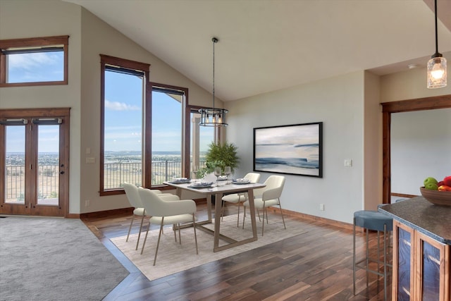 dining room featuring high vaulted ceiling, dark wood-type flooring, and a water view