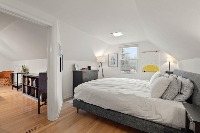 bedroom featuring lofted ceiling and light wood-type flooring