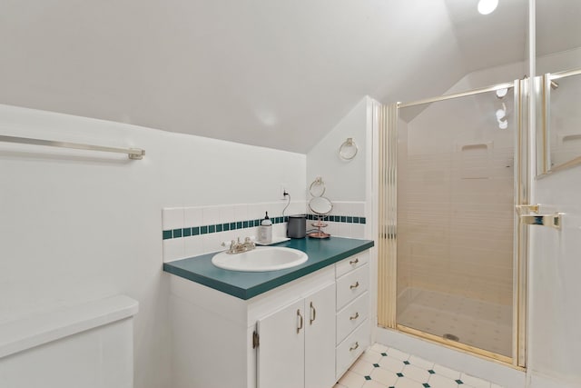 bathroom featuring vaulted ceiling, toilet, a shower with shower door, and vanity