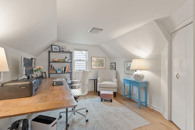 home office with vaulted ceiling and light hardwood / wood-style flooring