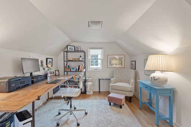 home office with vaulted ceiling and light hardwood / wood-style floors