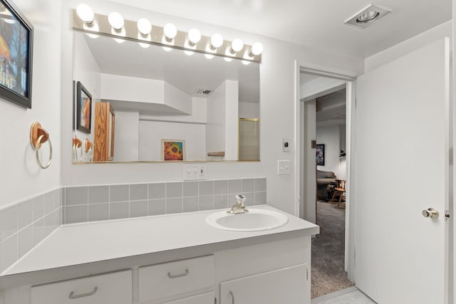 bathroom featuring vanity and tasteful backsplash