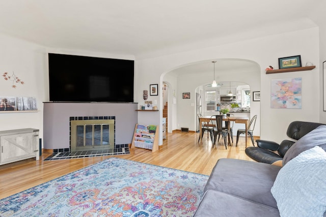 living room with hardwood / wood-style floors and a tiled fireplace