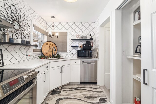 clothes washing area with sink, independent washer and dryer, and water heater