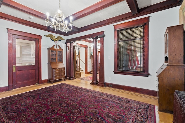 entryway with a chandelier, decorative columns, baseboards, and beam ceiling