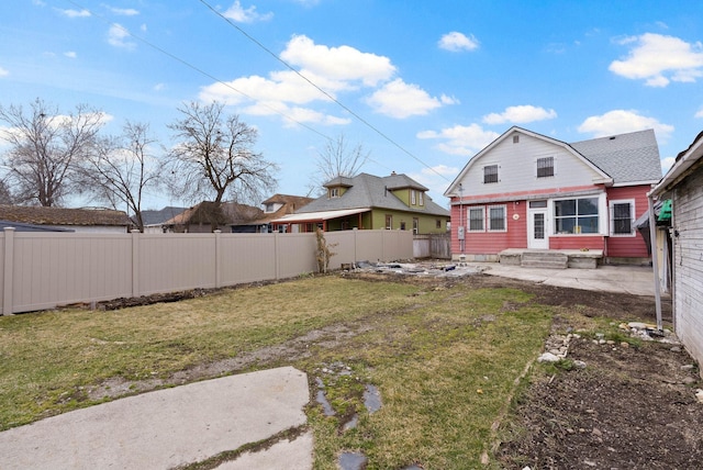 view of yard with entry steps and a fenced backyard