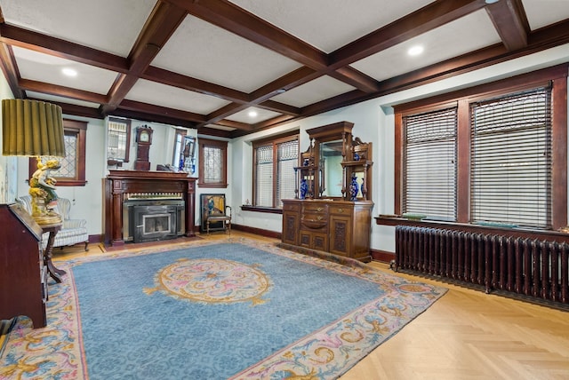 living room with beamed ceiling, radiator heating unit, a glass covered fireplace, coffered ceiling, and baseboards