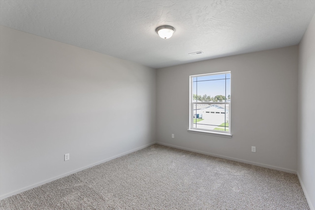 spare room featuring a textured ceiling and carpet floors