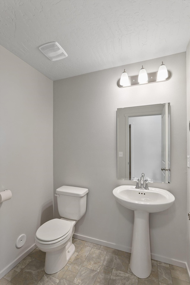 bathroom featuring toilet and a textured ceiling