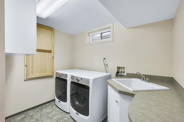 clothes washing area with cabinets, washer and clothes dryer, and sink