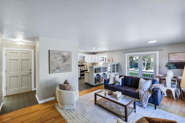 living room featuring light wood-type flooring and a textured ceiling