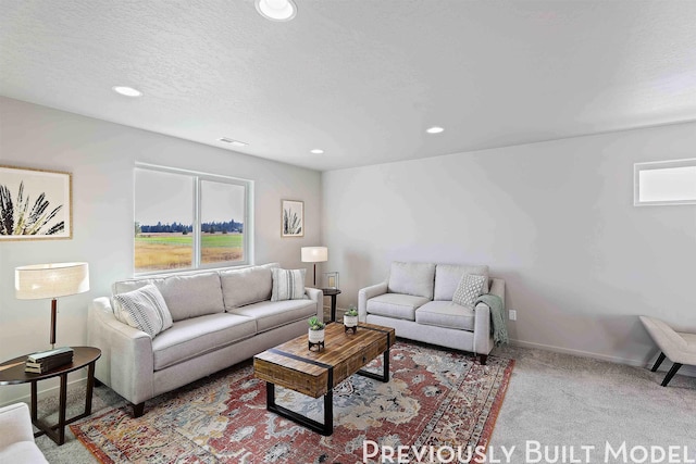 carpeted living room with plenty of natural light and a textured ceiling