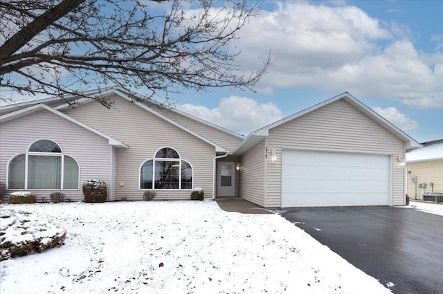 ranch-style home featuring a garage and cooling unit