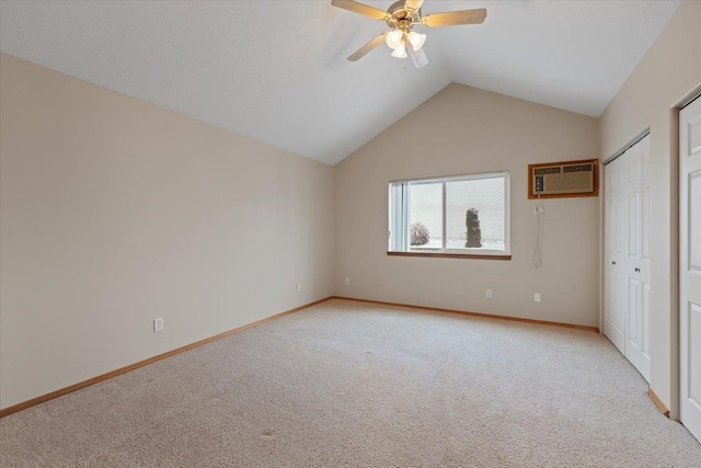 unfurnished bedroom featuring ceiling fan, light colored carpet, an AC wall unit, and lofted ceiling