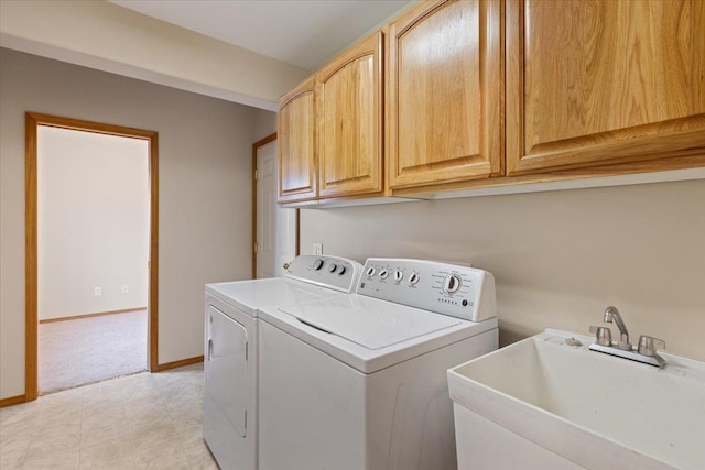 laundry area featuring washer and dryer, sink, and cabinets