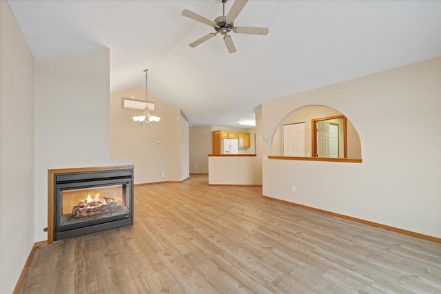 unfurnished living room with a multi sided fireplace, light hardwood / wood-style floors, ceiling fan with notable chandelier, and vaulted ceiling