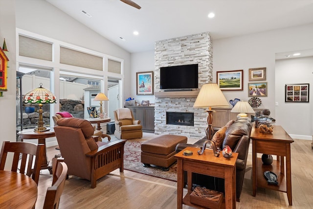 living room with light hardwood / wood-style floors, lofted ceiling, and a fireplace