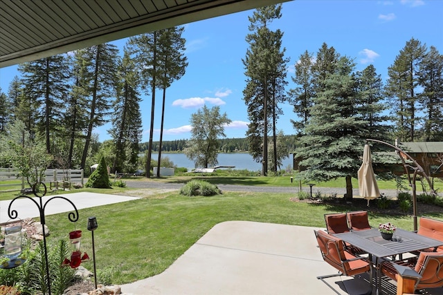 view of property's community featuring a water view, a yard, and a patio