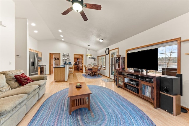 living room with lofted ceiling, light wood-type flooring, and ceiling fan