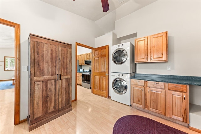 washroom with stacked washing maching and dryer, cabinets, light hardwood / wood-style floors, and ceiling fan