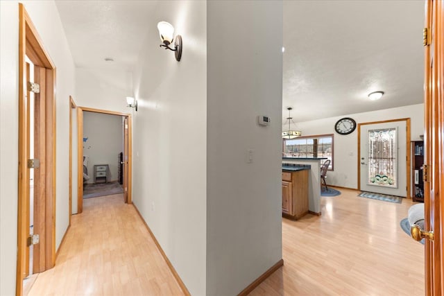 hallway featuring a textured ceiling and light hardwood / wood-style floors