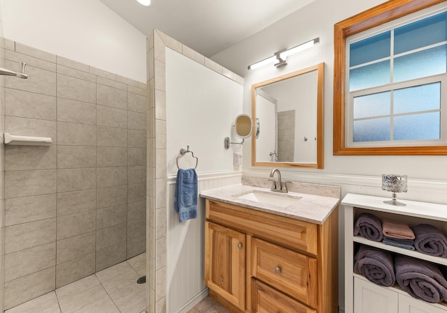 bathroom featuring tiled shower and vanity