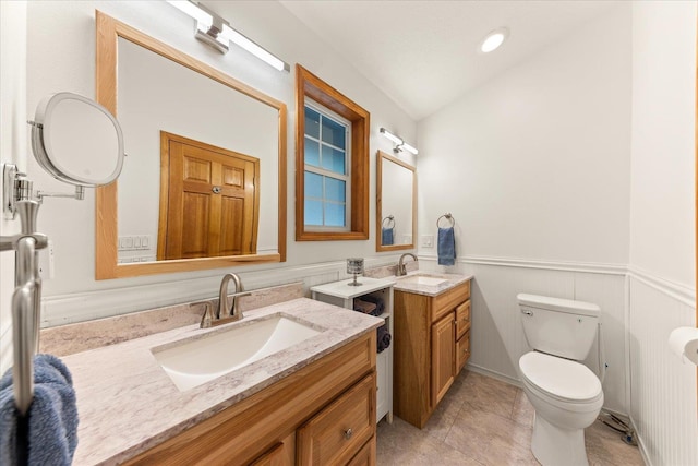 bathroom featuring toilet, lofted ceiling, tile patterned floors, and vanity