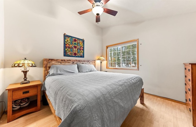 bedroom with ceiling fan, light hardwood / wood-style flooring, and lofted ceiling