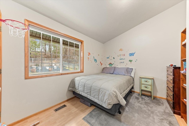 bedroom with hardwood / wood-style flooring and vaulted ceiling