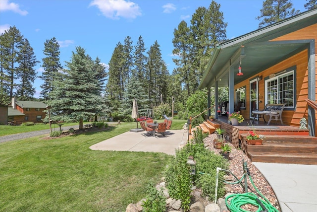 view of yard featuring covered porch and a patio