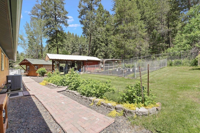 view of yard with central air condition unit and an outbuilding