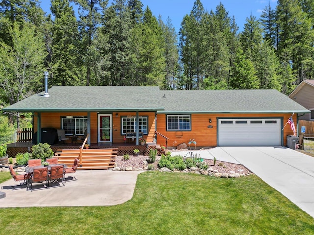 ranch-style house featuring a front yard, covered porch, and a garage