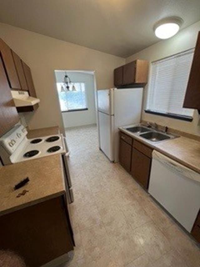 kitchen with a notable chandelier, decorative light fixtures, sink, and white appliances