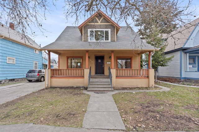 bungalow featuring covered porch and a front lawn