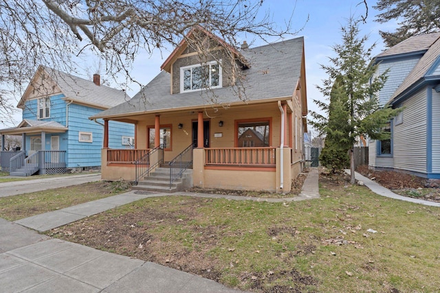 bungalow-style home featuring a front lawn and covered porch