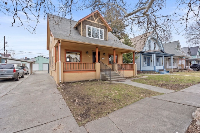 bungalow featuring an outbuilding, a front yard, a porch, and a garage