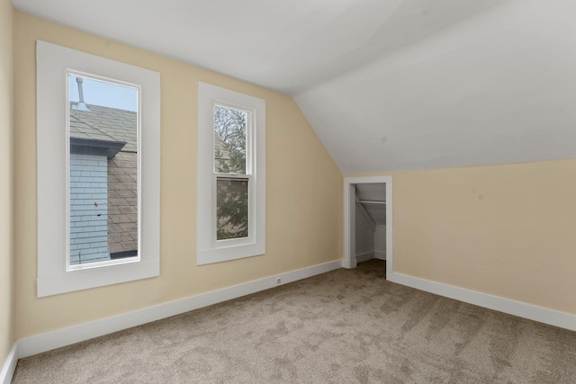 additional living space with lofted ceiling and light colored carpet