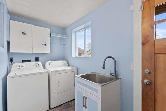 laundry area featuring cabinets, washer and clothes dryer, and sink