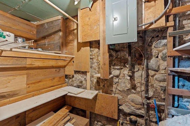 interior space with electric panel and wooden walls