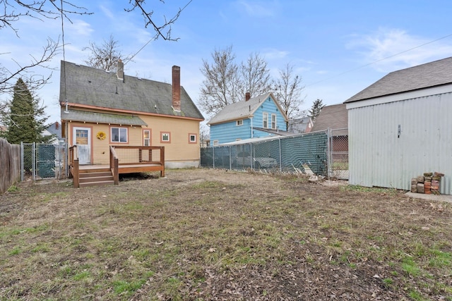 back of property with a deck and a yard