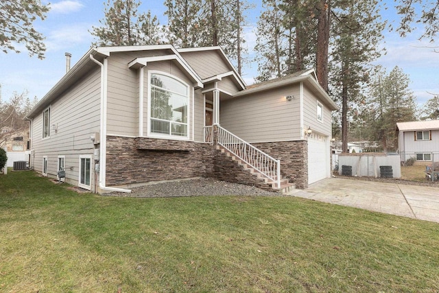 view of front of house featuring a front lawn, a garage, and cooling unit