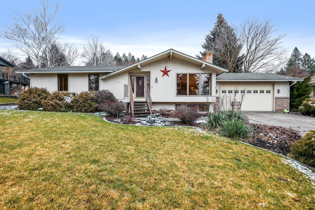 view of front of home with a front yard and a garage